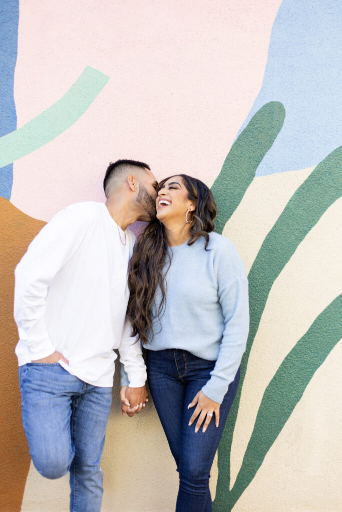 Smiling couple with a colorful backdrop.
