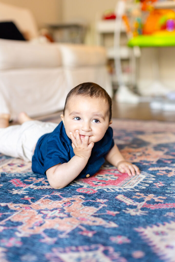 Baby Paul exudes joy as he plays on the living room floor during the photoshoot.