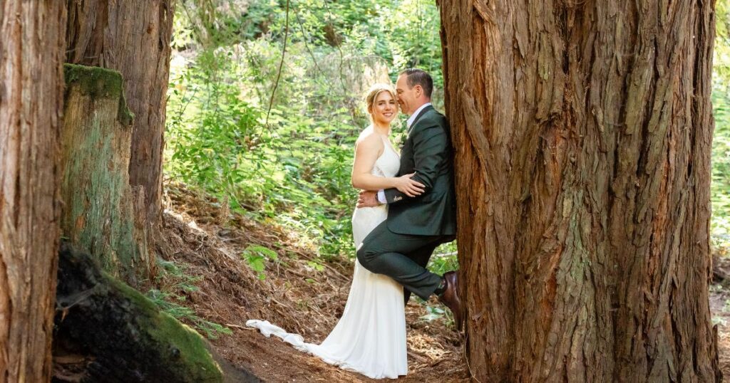 The couple poses amidst the majestic Redwood trees.